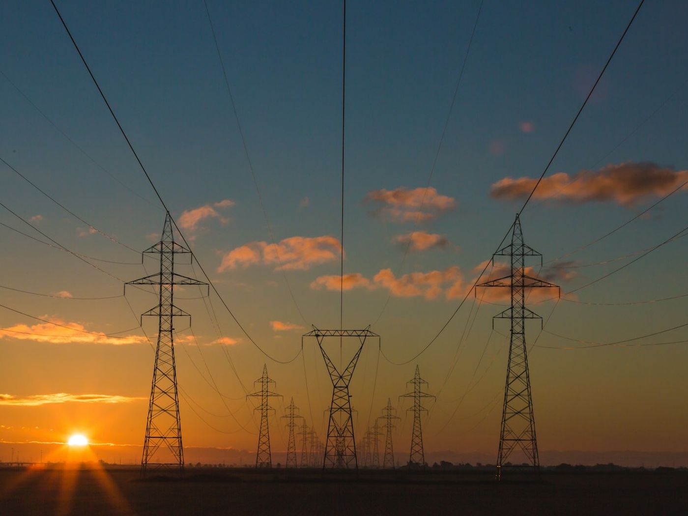 High-voltage power transmission lines at sunset